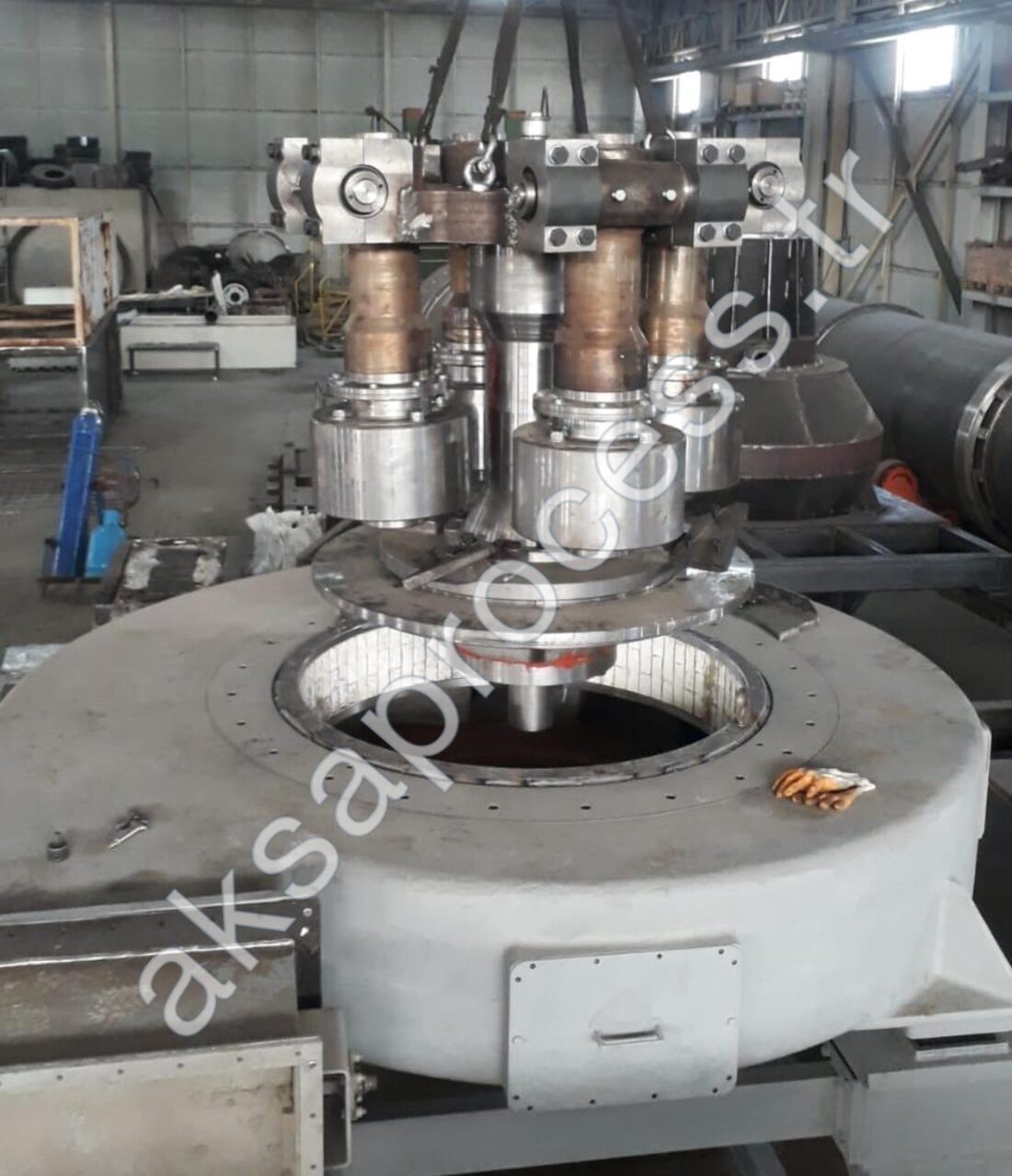 Descenso del conjunto de rodillos pendulares a la cámara de molienda en nuestro taller: cuatro rodillos con sus muñones, alojamientos de sellos mecánicos y revestimiento del anillo de molienda